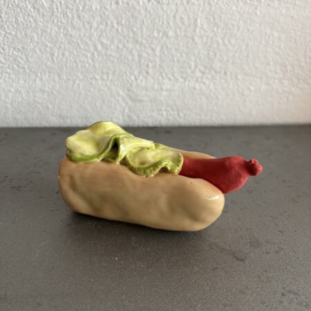 Hotdog i keramik med titlen "En 1/2 Hotdog"